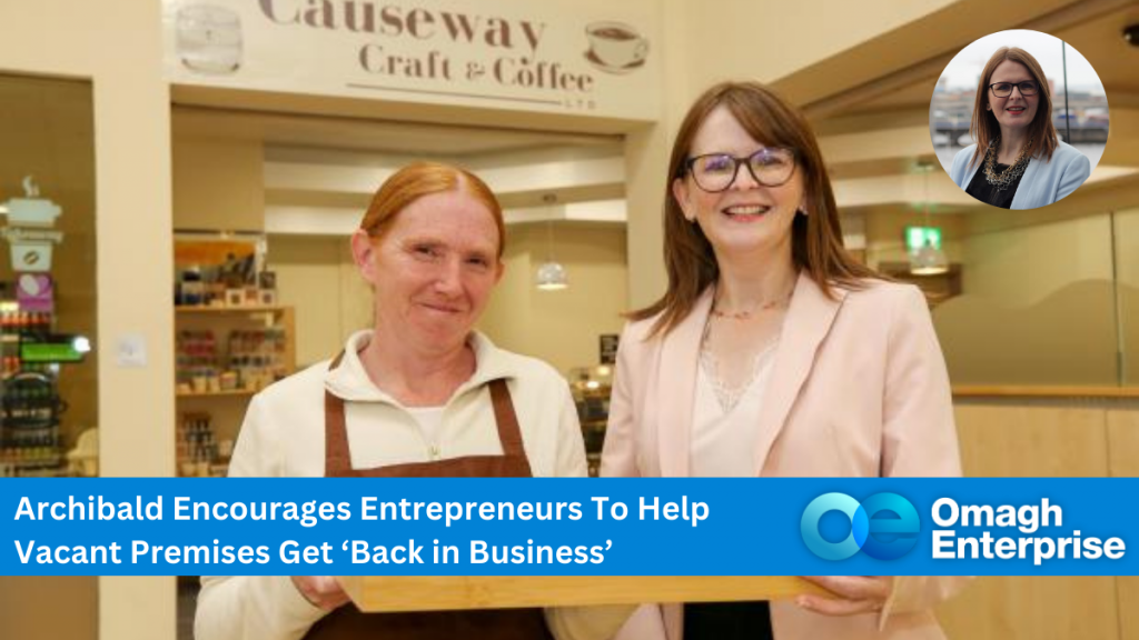 Dr Caoimhe Archibald at Causeway Craft and Coffee in Coleraine, with an employee. Blue banner along the bottom, with white text "Archibald Encourages Entrepreneurs To Help Vacant Premises Get ‘Back in Business’" Omagh Enterprise logo within banner