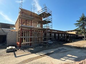 Inside site. Basic brickwork shell of building. Scaffolding round the wooden shell of main entrance.