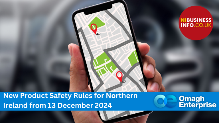 A hand holds a smartphone displaying a map with two location pins. A banner reads, New Product Safety Rules for Northern Ireland from 13 December 2024, with logos for nibusinessinfo.co.uk and Omagh Enterprise.