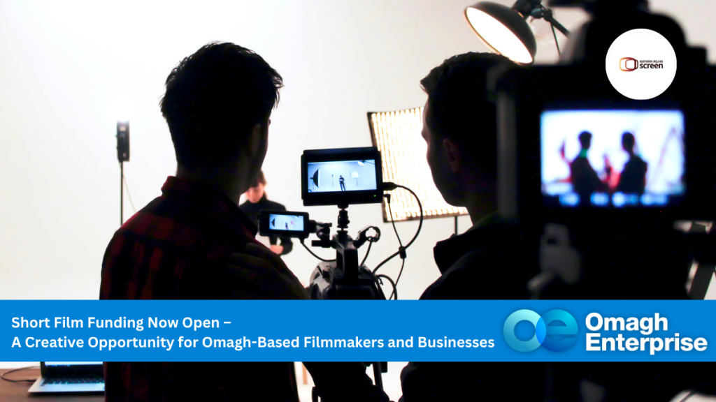 Two people film a scene in a studio, with cameras and lighting equipment visible. An overlay text announces short film funding for Omagh-based filmmakers and businesses.