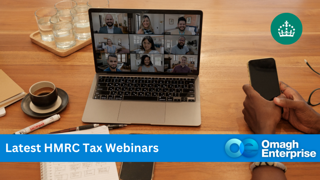 A laptop on a table displays a video call with multiple participants. A person holds a phone nearby. Text reads "Latest HMRC Tax Webinars" and "Omagh Enterprise.