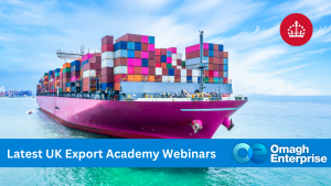A large cargo ship loaded with colorful shipping containers sails on blue water. A banner at the bottom reads Latest UK Export Academy Webinars with the Omagh Enterprise logo. A crown icon appears in the top right corner.