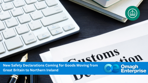 A keyboard and a document titled Customs Declaration are shown. A blue banner at the bottom says, New Safety Declarations Coming for Goods Moving from Great Britain to Northern Ireland. Omagh Enterprise logo is at the bottom right.
