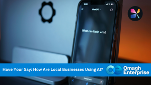 A smartphone displaying a ChatGPT prompt is placed in front of a blurred laptop, with a banner asking how local businesses use AI and the Omagh Enterprise logo.