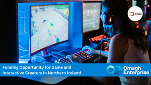 A person uses a gaming computer in a dark room, with a banner promoting funding for game and interactive creators in Northern Ireland by Omagh Enterprise and NI Screen.