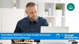 A man sits at a desk using a laptop and taking notes. A banner promotes free HMRC webinars to help Omagh businesses understand tax and payroll, with Omagh Enterprise branding.