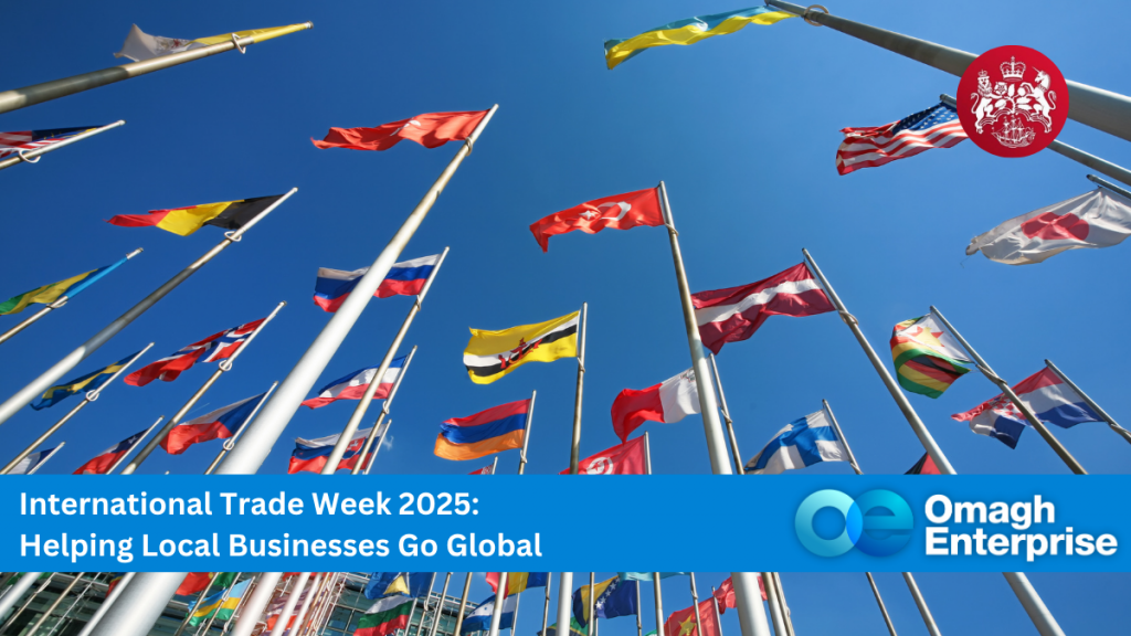 Rows of international flags wave against a blue sky, with a banner reading "International Trade Week 2025: Helping Local Businesses Go Global" and Omagh Enterprise logos.