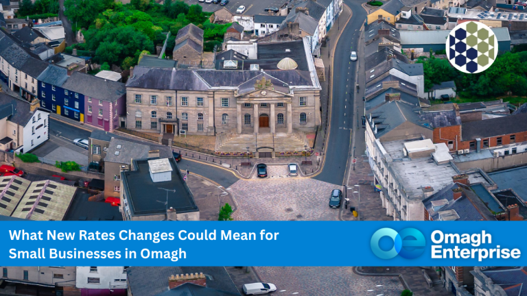Aerial view of a historic building in the center of Omagh, surrounded by roads and shops, with a banner about rates changes for small businesses.
