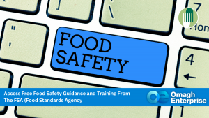 A keyboard with a blue key labeled "FOOD SAFETY," promoting free food safety guidance and training from the Food Standards Agency, by Omagh Enterprise.