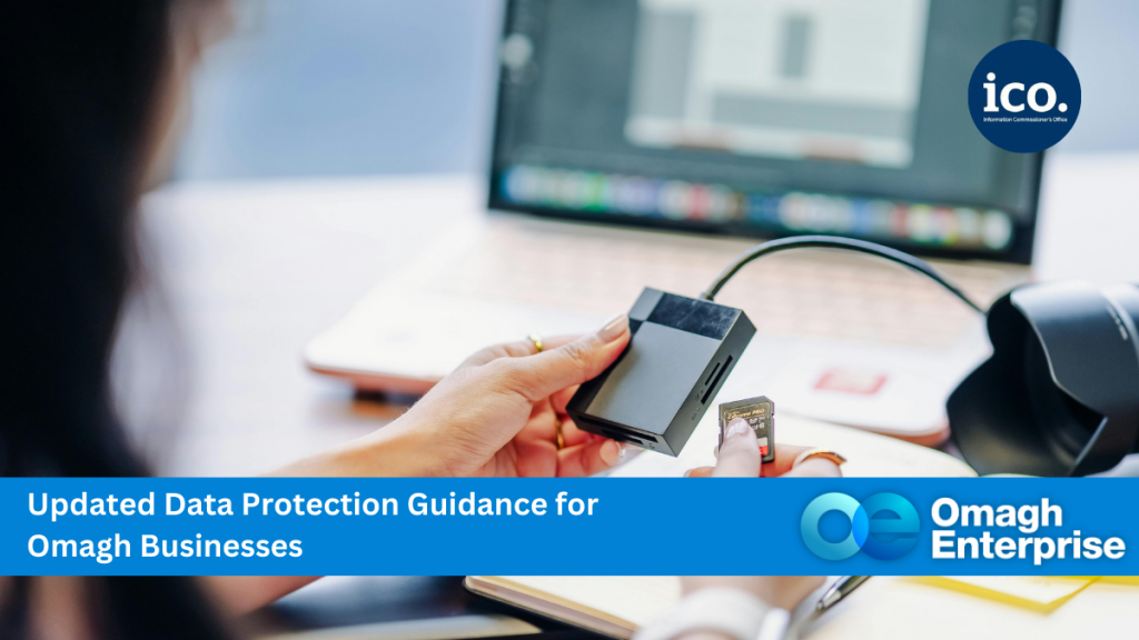 A person inserts an SD card into a card reader beside a laptop. Text overlay promotes updated data protection guidance for Omagh businesses by Omagh Enterprise and the ICO.