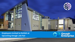Modern Omagh Leisure Complex building at dusk with sign reading "Omagh Enterprise" and text inviting employers to exhibit at an upcoming Omagh job fair.