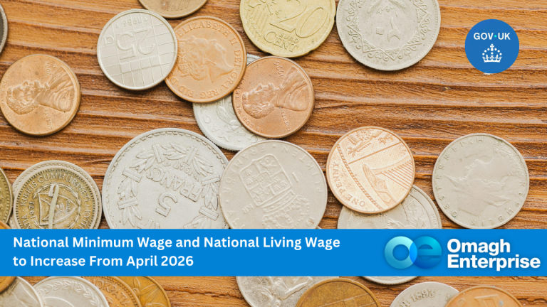 A variety of British coins scattered on a surface with a GOV.UK notice about minimum and living wage increases from April 2026, and Omagh Enterprise branding at the bottom.
