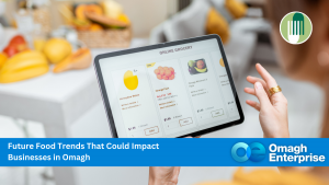 A person shops for fresh produce on an online grocery website using a tablet. The image has the text: "Future Food Trends That Could Impact Businesses in Omagh – Omagh Enterprise.