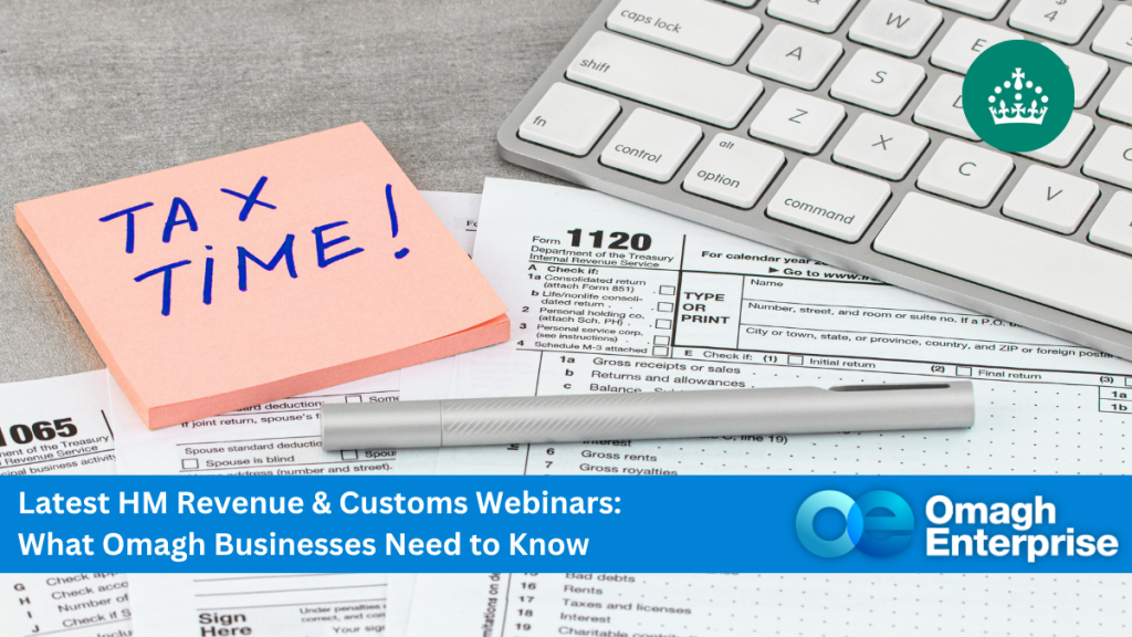 A desk with tax forms, a keyboard, a silver pen, and a pink sticky note reading "TAX TIME!" alongside a banner for an Omagh Enterprise tax webinar.