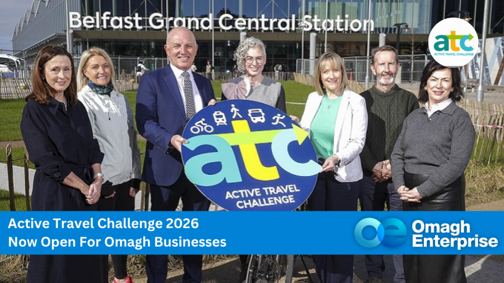A group of people stand outside Belfast Grand Central Station holding an "Active Travel Challenge" sign; Omagh Enterprise and event details are displayed.