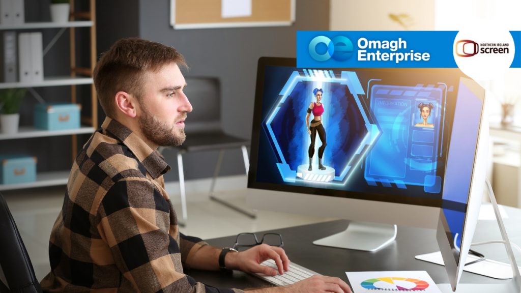 A man sits at a desk using a computer displaying a futuristic virtual character. The screen shows digital graphics and an avatar. Logos for Omagh Enterprise and Northern Ireland Screen are in the corner.