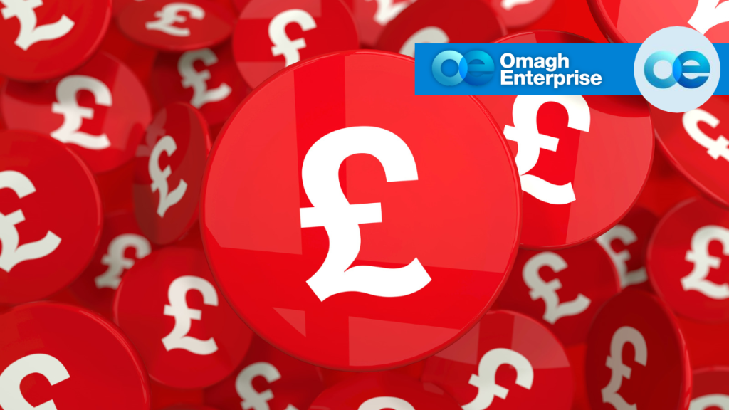 A large collection of red circular tokens featuring a white British pound sterling symbol, with the Omagh Enterprise logo in the top right corner.