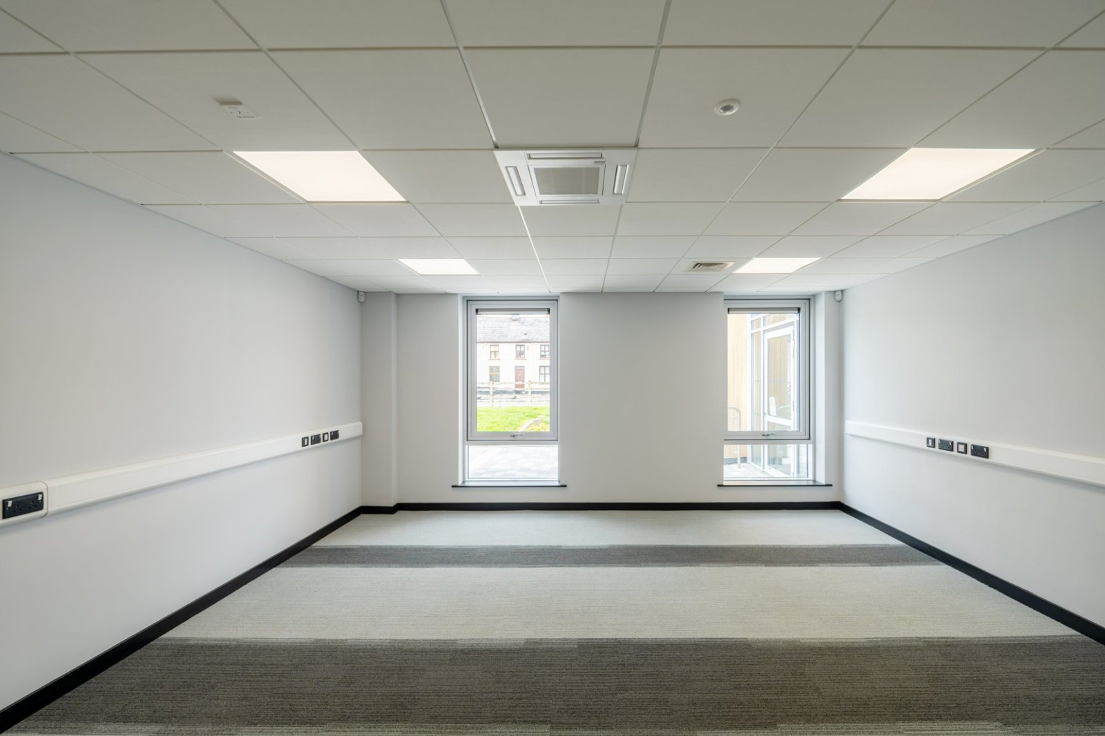 Empty private office to rent with two windows and grey carpet at Omagh Enterprise Digi-Hub, Omagh, County Tyrone