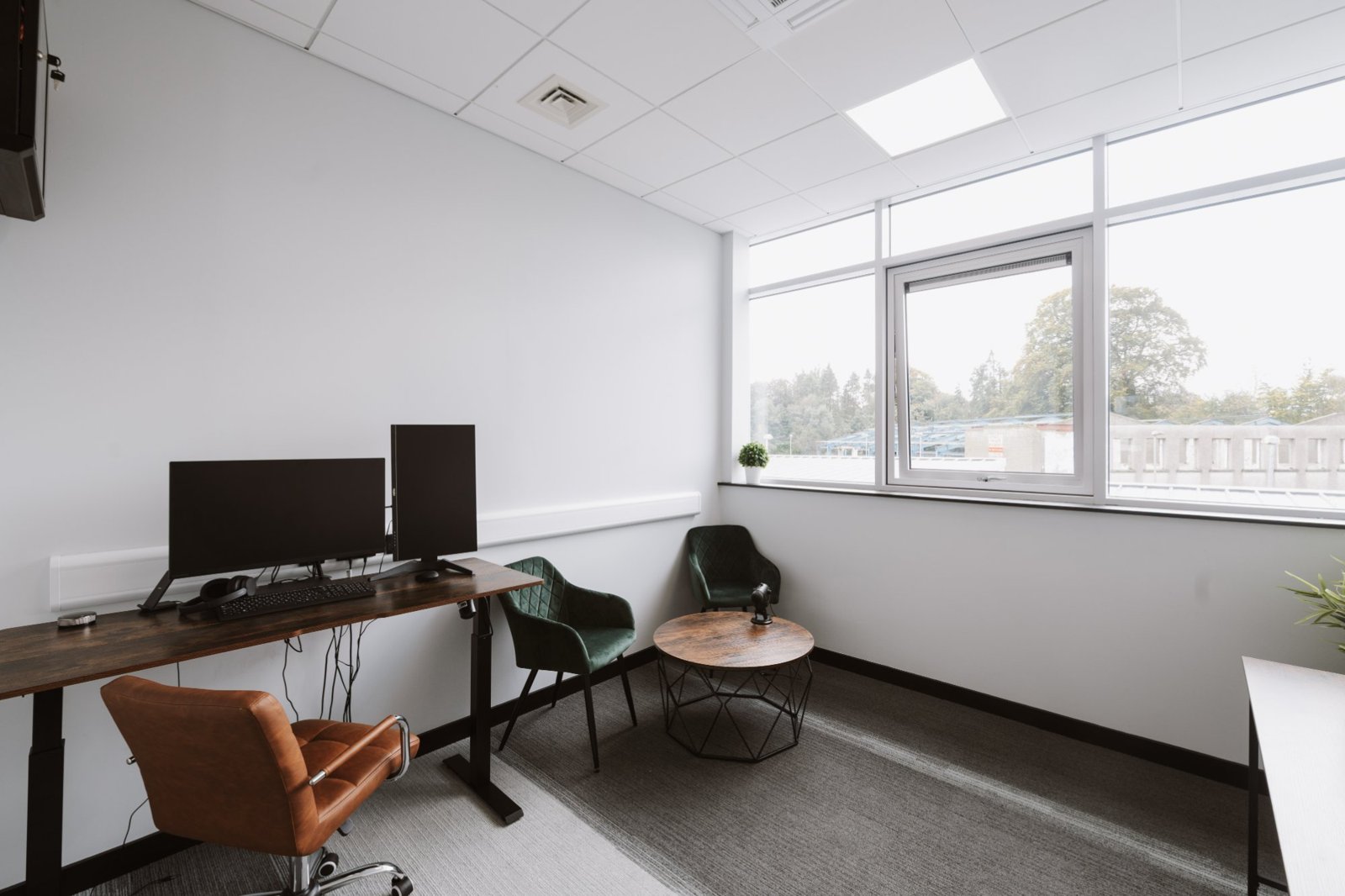 Furnished private office with standing desk, monitors and armchairs at Omagh Enterprise Digi-Hub, Omagh
